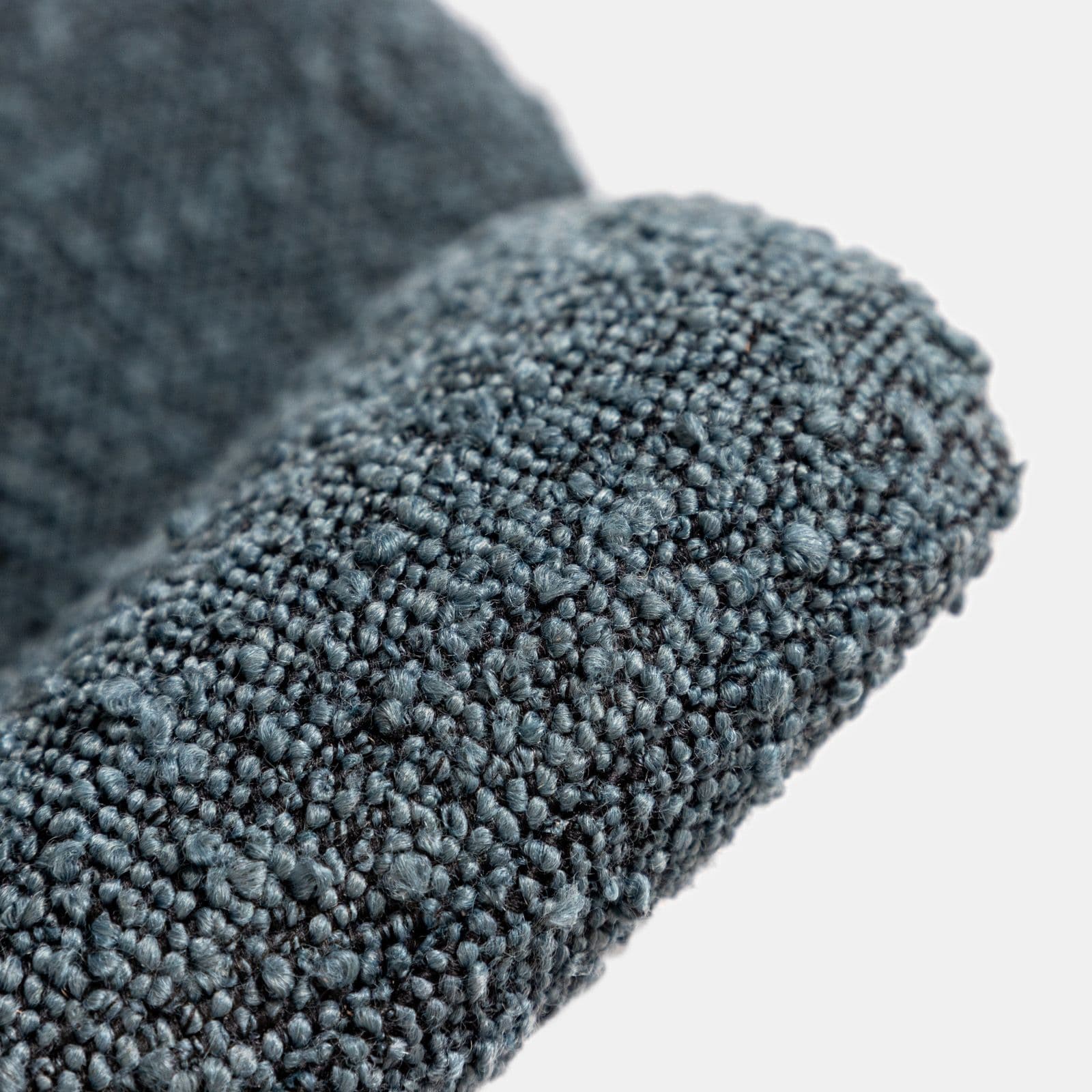 Poltrona in tessuto bouclé blu scuro con schienale avvolgente e gambe in metallo nero - Rosabel